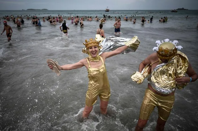 A bather poses as hundreds of people take part in a traditional “disguised” sea bath to mark the New Year's celebrations in Dinard, western France on December 31, 2022. (Photo by Loic Venance/AFP Photo)