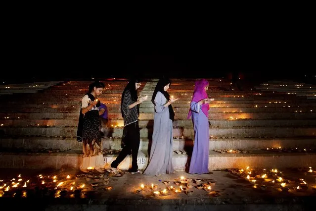 Women light candles to celebrate Pakistan's Republic Day in Karachi, Wednesday, March 23, 2016. Pakistan marked its national holiday on Wednesday commemorating the adoption of the country's first constitution. (Photo by Shakil Adil/AP Photo)