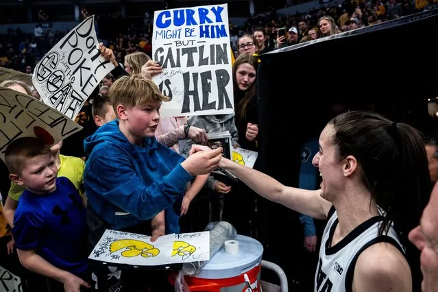 Iowa guard Caitlin Clark (22) gives a fan her headband during the Big Ten Women's Basketball tournament quarterfinals at the Target Center in Minneapolis, Minn. on March 8, 2024. (Photo by Lily Smith/The Register)
