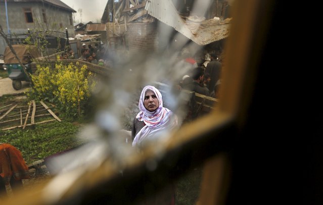 A Kashmiri Muslim woman is seen through a bullet hole on a window of a damaged house after a gunbattle in Gudoora village in south Kashmir April 6, 2016. Suspected militant Bilal Ahmad was killed in a gunbattle with Indian security forces on Tuesday evening in south Kashmir, and one a residential house was damaged, local media reported. (Photo by Danish Ismail/Reuters)