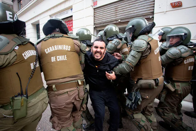 A demonstrator is detained by riot police during a teachers' protest against a government's plan that will be implemented in 2020 in which History and Physical Education will be optional in secondary school's 3rd and 4th year, in Santiago, on June 20, 2019. (Photo by Claudio Reyes/AFP Photo)