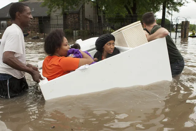 Residents of the Arbor Court apartments evacuate their flooded apartment complex in a refrigerator on Monday, April 18, 2016, in The Woodlands, Texas. (Photo by Brett Coomer/Houston Chronicle via AP Photo)