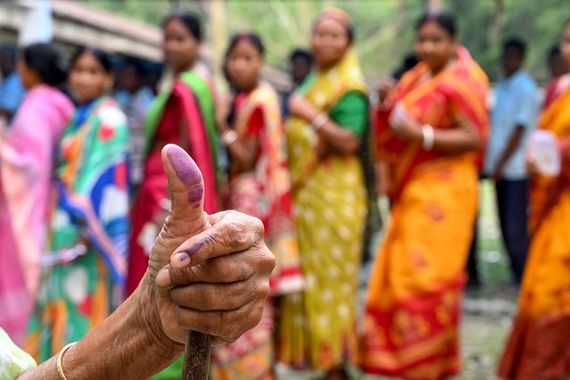 A woman shows her inked finger after casting her ballot to vote in the first phase of India's general election at a polling station in Kalamati village, Dinhata district of Cooch Behar in the country's West Bengal state on April 19, 2024. (Photo by Dibyangshu Sarkar/AFP Photo)