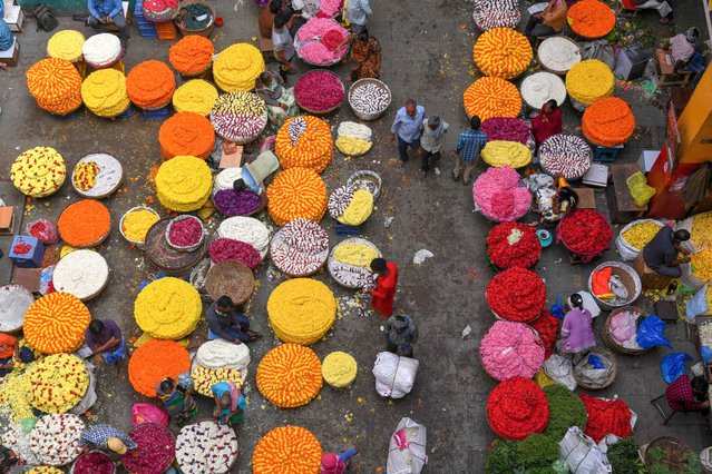 Flower vendors sell garlands in market ahead of the Makar Sankranti harvest festival in Bangalore on January 12, 2022. (Photo by Manjunath Kiran/AFP Photo)