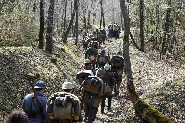 French, in blue, and German members of World War I historical associations march into a trench near the bunker of Bezonvaux, in the national forest of Verdun. (Photo by Charles Platiau/Reuters)