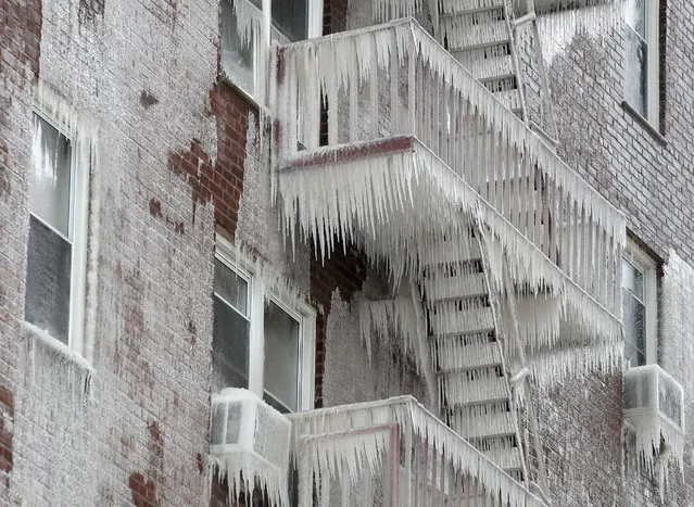 Ice covers the fire escape of an apartment building that caught fire, Wednesday, March 15, 2017, in Yonkers, N.Y. Authorities say the fire, which may have started on the fifth floor early Wednesday morning, has left one person dead and forced dozens of people into the cold. (Photo by Julie Jacobson/AP Photo)