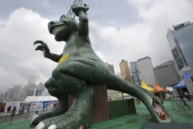 A woman plays on a dinosaur slide at an amusement park in Hong Kong, Thursday, June 25, 2015. (Photo by Vincent Yu/AP Photo)