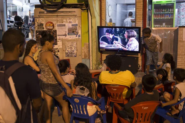 In this Oct.19, 2012 file photo, people watch the final chapter of the soap opera Avenida Brasil in a small outdoor plaza in the Dona Marta slum in Rio de Janeiro, Brazil. A top soap opera star in Brazil on Tuesday, April 4, 2017, apologized for sexually harassing a female colleague on set, doing an about-face after days of claiming the woman was confusing his villainous character with reality. In an open letter Tuesday, Jose Mayer acknowledged treating fashion stylist Susllem Tonani inappropriately. (Photo by Felipe Dana/AP Photo)