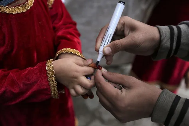 A health worker marks the finger of a child after receiving the polio vaccine in Lahore, Pakistan, Monday, January 24, 2022. Pakistani authorities on Monday launched this year's first nationwide anti-polio campaign despite facing a sudden surge of coronavirus cases in an effort aimed eradicating the crippling children's disease. (Photo by K.M. Chaudhry/AP Photo)