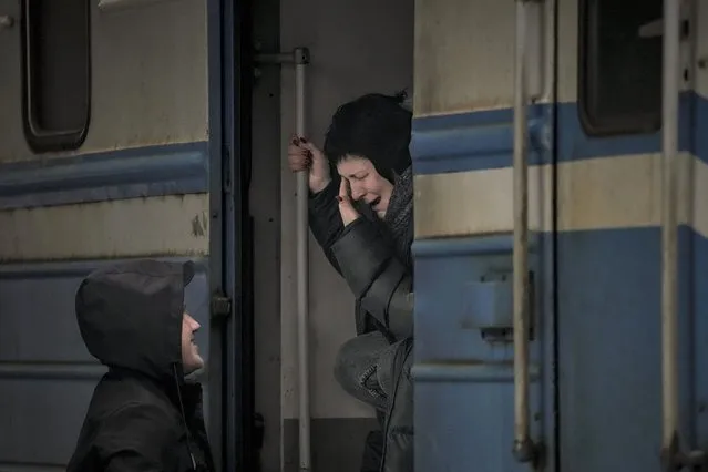 A woman on a Lviv bound train cries while she bids goodbye to a man in Kyiv, Ukraine, Saturday, March 12, 2022. (Photo by Vadim Ghirda/AP Photo)