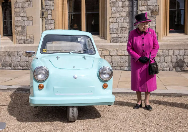 Britain's Queen Elizabeth stands next to an old subsidised, low cost mobility scooter from the 1960's, during a ceremony in Windsor Castle, Windsor April 25, 2017. (Photo by Richard Pohle/Reuters)
