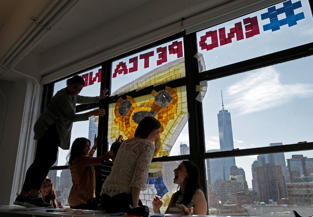 Employees create an image promoting pet cancer awareness month on a window with Post-it notes at the Horizon Media offices at 75 Varick Street in lower Manhattan, New York, U.S., May 18, 2016. (Photo by Mike Segar/Reuters)