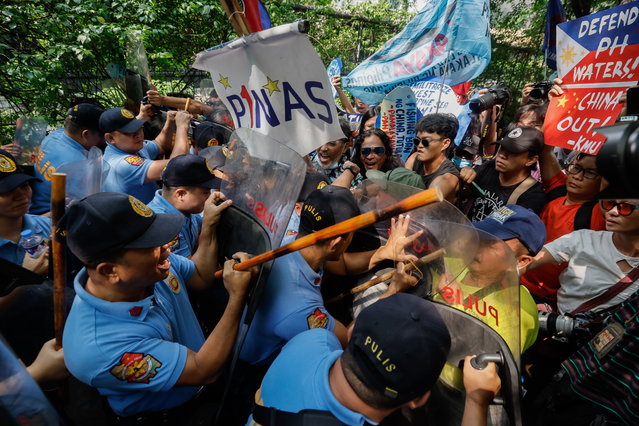 Police block protesters holding a rally to criticize agressive sea maneuvers of Chinese defense units against Philippine vessels in the South China Sea, outside China's consular office in Makati City, Metro Manila, Philippines, 14 June 2024. The protesters opposed plans by China to implement trespassing rules in disputed areas of the South China Sea, a move that could further endanger Philippine defense contingents and Filipino fishing workers. (Photo by Rolex Dela Pena/EPA)