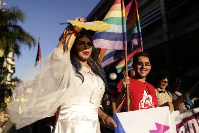 A participant in the “Somos Gay” march, or We're Gay march, shades her face from the sun with a fan in Asuncion, Paraguay, Saturday, July 18, 2015. The LGBT community marched in support of equality under the law for same s*x marriage. (Photo by Jorge Saenz/AP Photo)