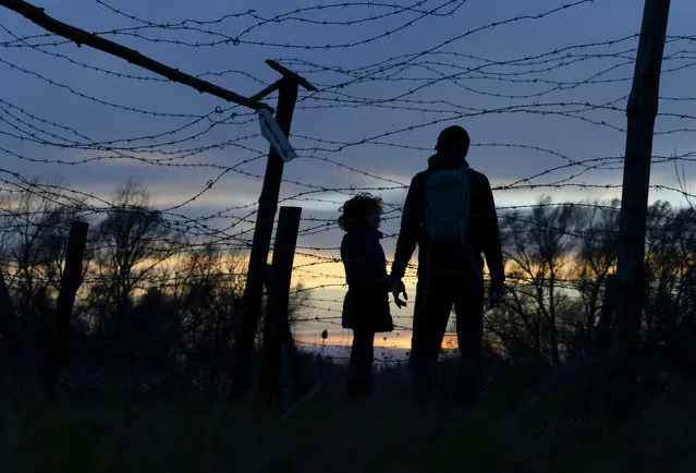 A father with his son visit the Freedom memorial, leftovers of the barb wired fence dividing Austria from the former Czechoslovakia, at Devinska Nova Ves, Slovakia on November 17, 2019 to commemorate 30th anniversary of the peaceful Velvet Revolution  that toppled the Communist regime in former Czechoslovakia 30 years ago. (Photo by Joe Klamar/AFP Photo)