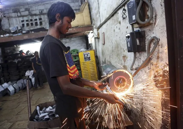 An Indian worker grinds metal to finish a part made for heavy vehicles at an industrial unit in Bangalore, India, Tuesday, May 31, 2016. India says its economy grew 7.6 percent in the financial year that ended March 31 and a swift 7.9 percent in the last quarter of the year keeping its position as the world's fastest growing major economy. (Photo by Aijaz Rahi/AP Photo)
