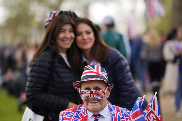 A man dress in a British union flag suit smiles as he queues along the Mall, part of the rout for the Coronation of King Charles, in London, Friday, May 5, 2023. King Charles III will be crowned King at Westminster Abbey on Saturday May, 6. (Photo by Petr Josek/AP Photo)