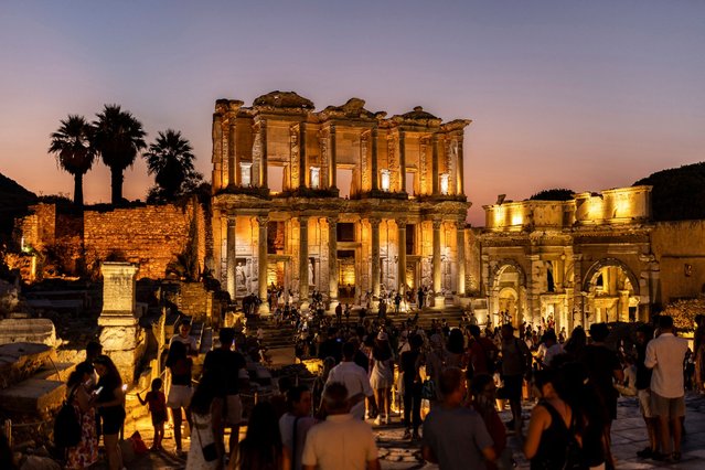 Tourists visit the illuminated ancient Greek city of Ephesus at night near Selcuk on July 23, 2024. (Photo by Kemal Aslan/AFP Photo)