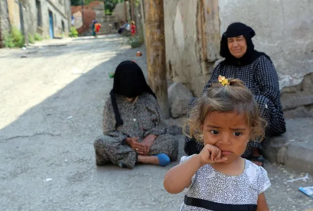 Syrian refugees sit in front of a derelict building in Haci Bayram neighborhood in Ankara, Turkey, Monday, July 27, 2015. The number of Syrian refugees in Turkey is estimated to be close to two million but only about 200,000 of them live in refugee camps. Some family live in makeshift shelters. Turkey hosts the largest number of refugees, according to recent U.N. figures. (Photo by Burhan Ozbilici/AP Photo)