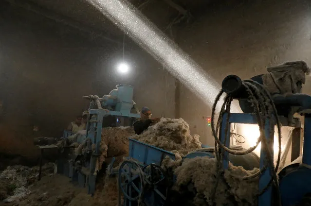 A laborer uses a piece of cloth as a mask to avoid dust while working at a cotton gin workshop in Peshawar, Pakistan on December 2, 2019. (Photo by Fayaz Aziz/Reuters)