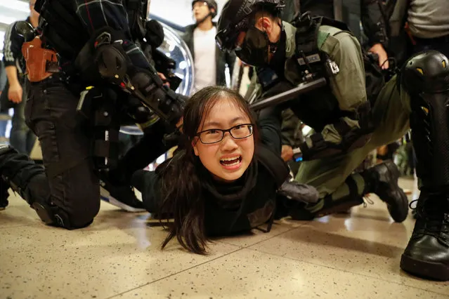 Police officers detain an anti-government protester during a demonstration inside a mall in Hong Kong, China on December 15, 2019. (Photo by Danish Siddiqui/Reuters)