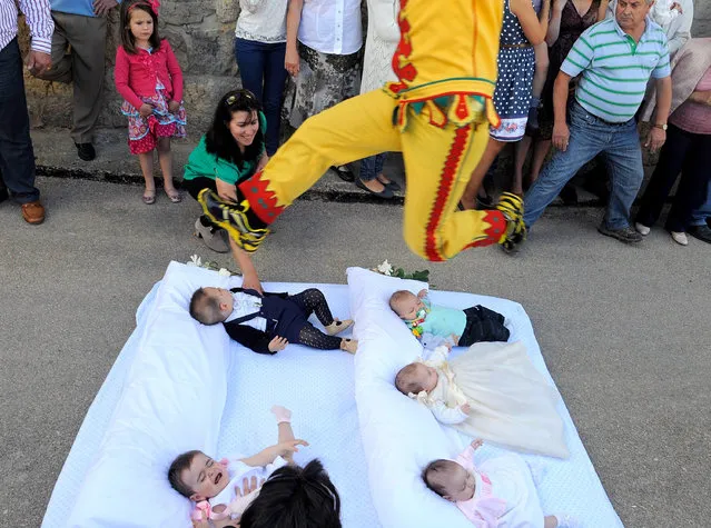 A man representing the devil leaps over babies during the festival of El Salto del Colacho (the devil's jump) on June 22, 2014 in Castrillo de Murcia, Spain. The festival, held on the first Sunday after Corpus Cristi, is a catholic rite of the devil cleansing babies of original sin. (Photo by Denis Doyle/Getty Images)