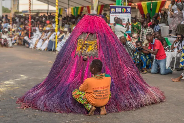 Voodoo devotees dressed as Zangbeto, the traditional Vodoo guardians of the night, parade on the main boulevard of Porto-novo in Benin on January 11, 2020. The 4th edition of the Porto Novo International Festival (FIP) takes place from January 4 to 12, 2020 in Porto-Novo. 1,200 cultural and ritual masks from several African countries paraded for a grand parade during the 4th edition of the International Festival of Culture, Arts and Vodun Civilization scheduled to date in Porto-Novo. (Photo by Yanick Folly/AFP Photo)
