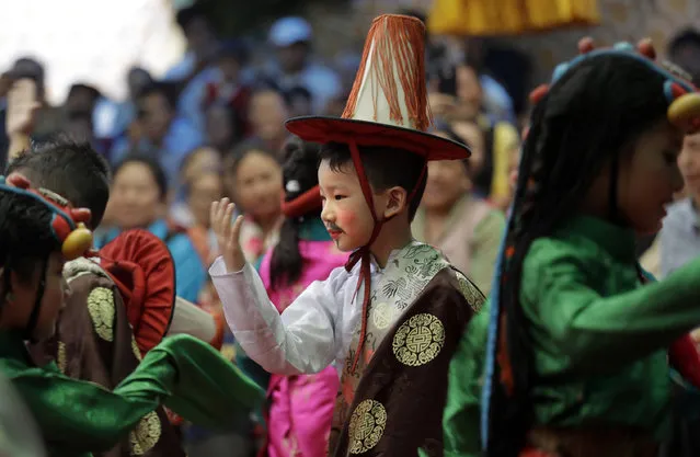 A Tibetan boy in traditional dress dances with others during celebrations marking the 82nd birthday of their spiritual leader the Dalai Lama at a Tibetan settlement in New Delhi, India, Thursday, July 6, 2017. Thousands belonging to Tibetan community waved white scarves and banners, lit incense and prayed for the Dalai Lama's long life as he turned 82 Thursday. The Dalai Lama is currently visiting the Jokhang Gonpa, a Buddhist monastery, built in Ladakh in the Indian portion of Kashmir. (Photo by Manish Swarup/AP Photo)