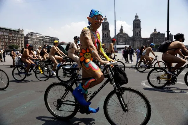People participate in the 15th World Naked Bike Ride at the Monument to the Revolution in Mexico City, Mexico on June 11, 2022. (Photo by Luis Cortes/Reuters)
