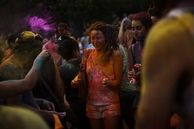 Revelers of the Holi Festival of Colours throw coloured powders in the air, in Madrid, Spain, Saturday, August 9, 2014. The festival is based on the Hindu spring festival Holi, also known as the festival of colours where participants colour each other with dry powder and coloured water. (Photo by Daniel Ochoa de Olza/AP Photo)