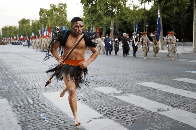 A Maori soldier runs as New Zealand's soldiers march down the Champs Elysees in Paris during a rehearsal of the annual Bastille Day military parade on July 12, 2016. (Photo by Thomas Samson/AFP Photo)