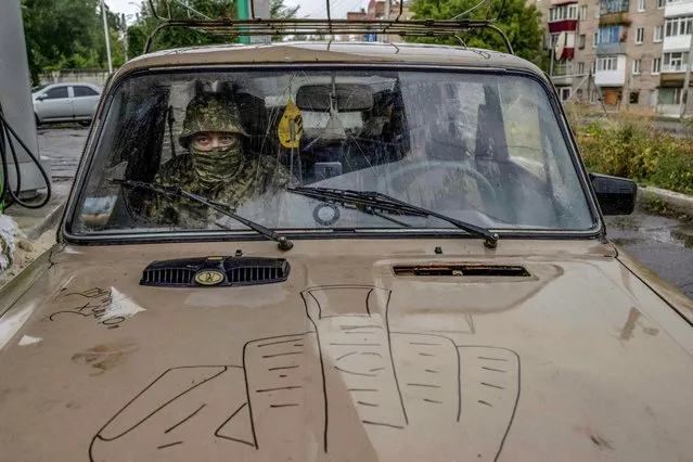 A Ukranian looks on as he sits in a car at a gas station during a rainy day in the city of Sloviansk, eastern Ukraine, on August 2, 2022, amid the Russian invasion of Ukraine. (Photo by Bulent Kilic/AFP Photo)