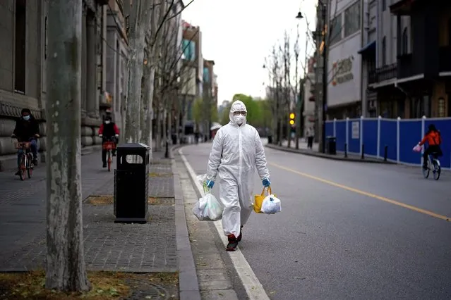 A man wearing a hazmat suit walks on a street in Wuhan, Hubei province, the epicenter of China's coronavirus disease (COVID-19) outbreak, March 28, 2020. (Photo by Aly Song/Reuters)