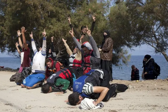 Syrian refugees raise their hands to the sky while praying, moments after arriving on the Greek island of Lesbos September 3, 2015. (Photo by Dimitris Michalakis/Reuters)