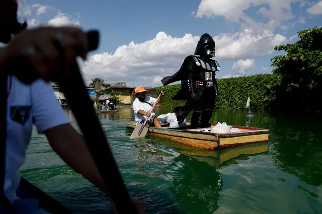 A village officer dressed as the Star Wars character Darth Vader rides a small boat to deliver relief goods to residents in the flooded Artex Compound in Malabon, Metro Manila, Philippines, May 4, 2020. (Photo by Eloisa Lopez/Reuters)