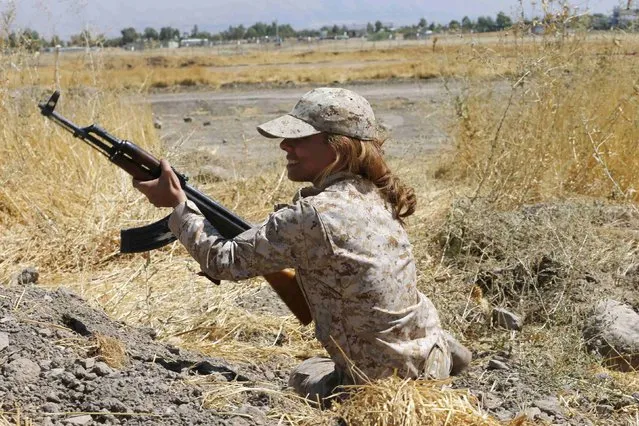 A Kurdish Peshmerga female fighter takes up a position during combat skills training before being deployed to fight Islamic State militants, at their military camp in Sulaimaniya, northern Iraq September 18, 2014. (Photo by Ahmed Jadallah/Reuters)