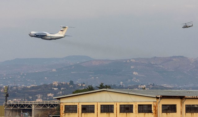 A Russian military aircraft takes off from Hmeimim air base as a Russian military helicopter Kamov KA-50 flies over the base in Syria's coastal Latakia, Syria, on December 15, 2024. (Photo by Umit Bektas/Reuters)