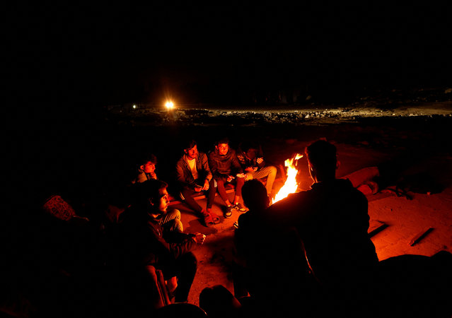 Palestinians sit by a fire to keep warm near the rubble of destroyed houses, amid a ceasefire between Israel and Hamas, in Jabalia, northern Gaza Strip, on February 3, 2025. (Photo by Mohammed Salem/Reuters)