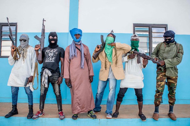 Togolese policemen, disguised as a terrorists, hold their weapons on October 20, 2022 as they take part in an anti-terrorism exercise at the Peacekeeping Operations Training Center (CEOMP). (Photo by Yanick Folly/AFP Photo)