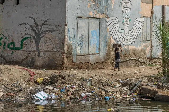 A picture taken on September 29, 2022 shows plastic and garbage floating on the bank of Nile River in the Egyptian capital of Cairo. (Photo by Khaled Desouki/AFP Photo)