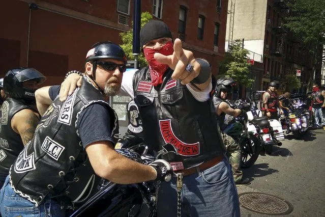 Motorcycle enthusiasts talk on East 3rd St as a large group of motorcycles gather at the Hell's Angels clubhouse in the Manhattan borough of New York, August 23, 2015. (Photo by Carlo Allegri/Reuters)