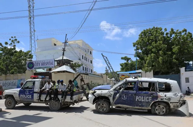 Somali police officers tow their car from the scene of a roadside explosion in Hodan district of Mogadishu, Somalia on July 8, 2020. (Photo by Feisal Omar/Reuters)