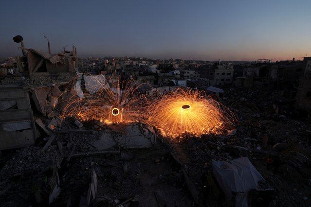 Palestinians spin steel wool sparklers amid the rubble of buildings, ahead of the holy fasting month of Ramadan, amid a ceasefire between Israel and Hamas, at Jabalia refugee camp, northern Gaza Strip, on February 28, 2025. (Photo by Mahmoud Issa/Reuters)
