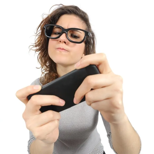 Geek woman playing with a smart phone. (Photo by Antonio Guillem/Getty Images)