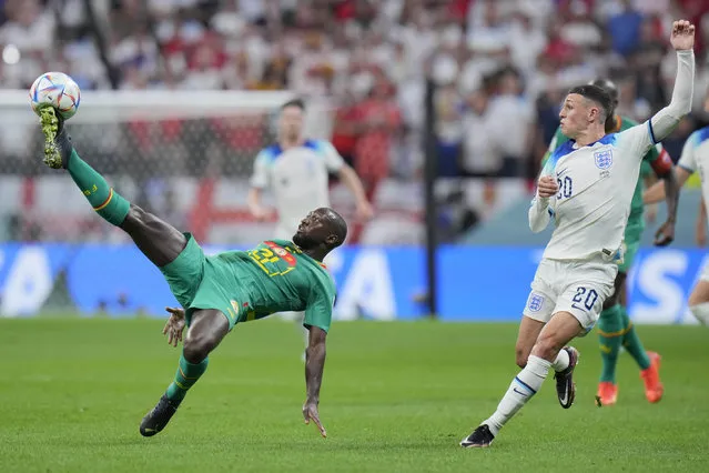 Senegal's Youssouf Sabaly, left, challenges with England's Phil Foden during the World Cup round of 16 soccer match between England and Senegal, at the Al Bayt Stadium in Al Khor, Qatar, Sunday, December 4, 2022. (Photo by Hassan Ammar/AP Photo)