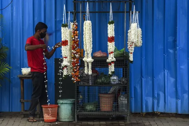 A street vendor prepares flower garlands at a Hindu temple in Colombo on July 2, 2020. (Photo by Ishara S. Kodikara/AFP Photo)