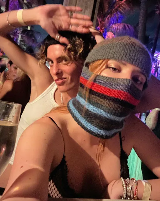 A masked American actress Bella Throne and her boyfriend snap a selfie in a crowd in the second decade of December 2022. (Photo by bellathorne/Instagram)