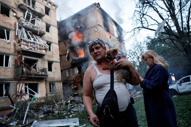 A resident holds his dog at the site of an apartment building damaged during a Russian strike in Kyiv, Ukraine on June 17, 2025. (Photo by Thomas Peter/Reuters)