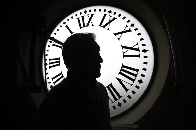 Watchmaker Jesus Lopez-Terradas is silhouetted against one of the clock-faces of the clockwork of the Puerta del Sol tower in Madrid, Spain, 26 December 2022 as it is prepared and checked to give the last twelve rings of the year during the midnight chimes of the clock tower that announces the New Year in the Spanish capital. (Photo by Sergio Perez/EPA/EFE)