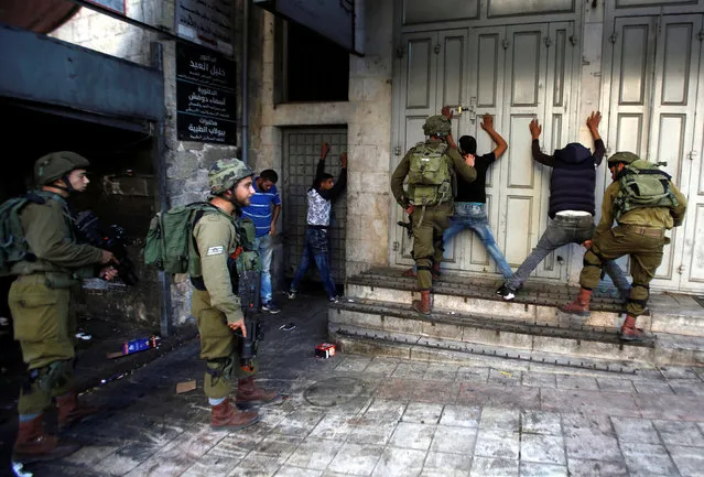 Israeli soldiers search Palestinians during clashes in the West Bank city of Hebron September 19, 2016. (Photo by Mussa Qawasma/Reuters)